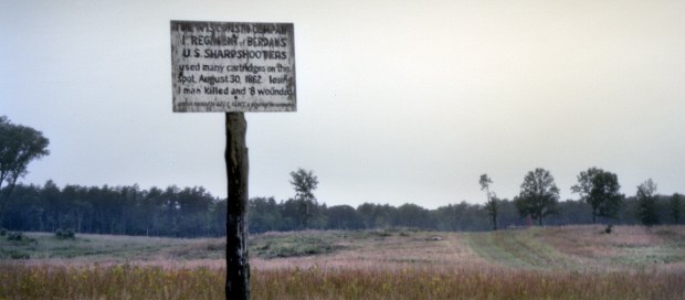 Facing the Deep Cut an old sign marking the spot and the exploits of a regiment of Wisconsin sharpshooters during the Battle of 2nd Manassas.